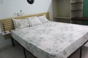博博迪乌拉Ranya的一间卧室配有一张带白色毯子和枕头的床。