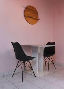 博博迪乌拉Ranya的一张桌子、两把椅子和一面墙上的镜子