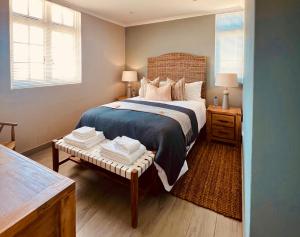 伊丽莎白港Cape Recife Lighthouse Luxury Villa的一间卧室配有一张床和一张桌子,上面配有毛巾