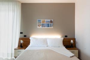 蒙特西尔瓦诺Hotel D'Atri的一间卧室配有带白色床单和枕头的床。