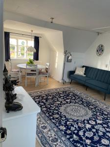 古兹耶姆ØsterLars blue Pearl的客厅配有蓝色的沙发和桌子