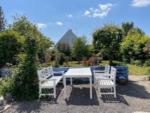 古兹耶姆ØsterLars blue Pearl的院子里的一张白色野餐桌和两把椅子