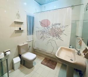 圣朱利安斯St Julian Rainbow的浴室设有卫生间、水槽和淋浴帘