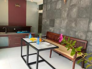 金巴兰巴厘岛大象精品别墅酒店的厨房配有桌子、长凳和桌子