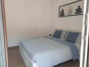斯楚雅Seafront Apartment Strunjan的白色卧室配有蓝色枕头的床