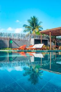 佩德拉斯港Villa Patacho Nature Apartamento 103 C的一座棕榈树游泳池和一座建筑