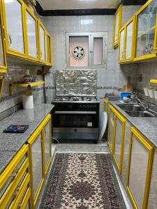 开罗Spacious flat 7 mins to Airport的厨房配有黄色橱柜和炉灶烤箱