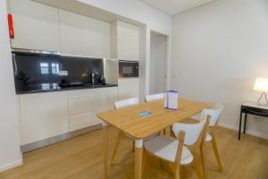 波尔图Porto Downtown Living - Picaria Apartments的厨房配有木桌和白色橱柜。