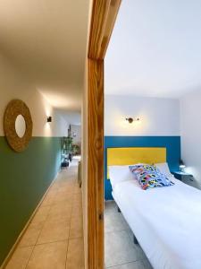 安道尔城Único Piso Colorido y Divertido En Ransol - Increibles Vistas al Rio y Naturaleza - Ideal Familias的卧室设有白色的床和绿色及蓝色的墙壁