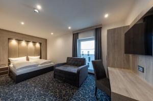 辛德尔芬根Hotel Business Bay das ehemalige Staycation Hotel的配有一张床和一把椅子的酒店客房