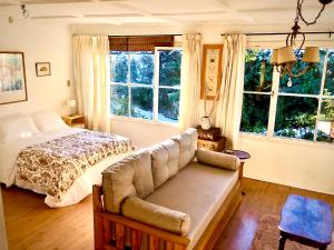 圣卡洛斯-德巴里洛切Casita excelente ubicación的一间卧室配有一张床、一张沙发和窗户。