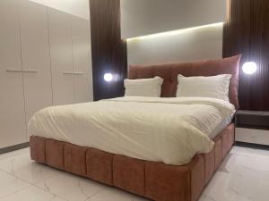 巴勒如拉斯فلل بيات الفيصل Bayat Al Faisal Villas的卧室内的一张大床和棕色床头板