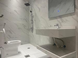 巴勒如拉斯فلل بيات الفيصل Bayat Al Faisal Villas的白色的浴室设有水槽和卫生间。