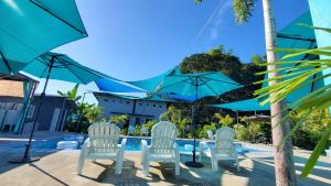 san juan la unionHidden Palms Inn的一组椅子和遮阳伞在游泳池边