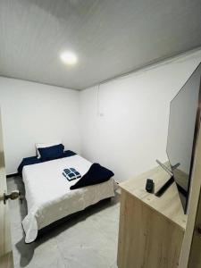 波帕扬Lugar encantador super equipado的一间卧室配有一张床和一张桌子上的电视