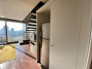 圣地亚哥Loft Smart Panoramico - Santiago的楼梯旁带冰箱的厨房