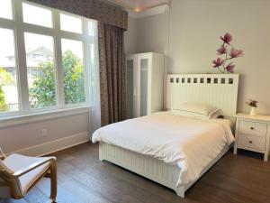 温哥华Vancouver West Cozy Retreat by Host Launch的卧室配有白色的床和窗户。