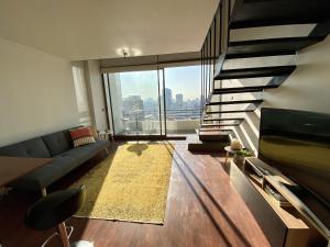 圣地亚哥Loft Smart Panoramico - Santiago的带沙发和大窗户的客厅