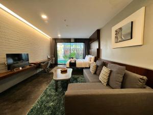 清莱NAI YA Hotel -SHA Extra Plus的带沙发、床和电视的客厅