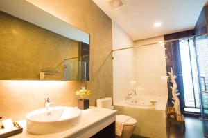 清莱NAI YA Hotel -SHA Extra Plus的一间带水槽、浴缸和卫生间的浴室
