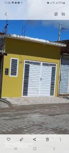 卡鲁阿鲁Casa Confortável的街上有白色门的黄色房子