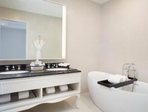 万隆万隆福朋喜来登酒店的带浴缸、水槽和镜子的浴室