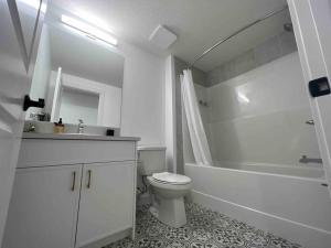 卡尔加里Cozy Retreat - Basement Hideaway - Closest to Banff in Calgary的白色的浴室设有卫生间、浴缸和水槽。