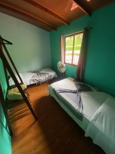 ArbolitoTabaco Lodge #1 a solo 5 mins de Playa Carrillo的客房设有两张双层床和一扇窗户。