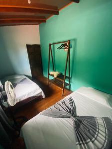 ArbolitoTabaco Lodge #1 a solo 5 mins de Playa Carrillo的绿墙客房内的两张床
