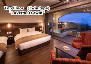 雾岛市La Vista Kirishima Hills的酒店客房设有一张床和一个阳台。