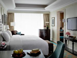 深圳深圳东海朗廷酒店的酒店客房设有一张白色大床和一张桌子。