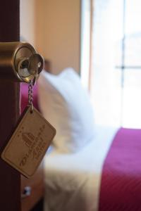 拉巴斯Hotel Diamante Azul的挂在门上的标签,上面有一张床