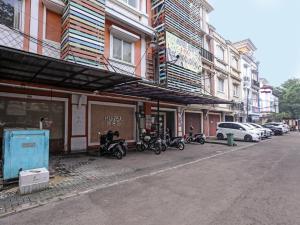 South TangerangSUPER OYO 92672 Hotel Bsd的停在大楼前的一组摩托车