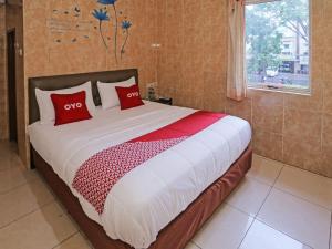 South TangerangSUPER OYO 92672 Hotel Bsd的一间卧室配有一张带红色枕头的大床