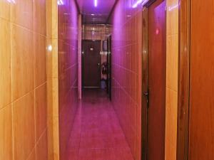 South TangerangOYO 92674 Hotel Ciputat的浴室里一个紫色灯的空走廊