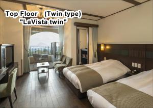雾岛市La Vista Kirishima Hills的酒店客房设有两张床和电视。