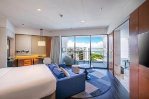 三亚三亚山海天大酒店，傲途格精选（万豪国际旗下酒店）的酒店客房,配有床和蓝色的沙发