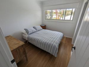 巴托湾Bateau Bay Retreat的一间小卧室,配有床和窗户