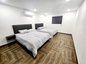 华雷斯城Departamento Pitagoras No 3的一间卧室设有两张床,铺有木地板