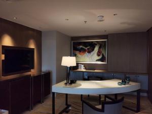 三亚三亚山海天JW万豪酒店(自然采光儿童俱乐部)的一间带台灯的桌子和一台电视机的房间