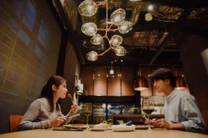 大阪Aloft Osaka Dojima的坐在餐厅桌子上的男女