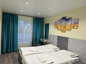 乔尔蓬阿塔卡普里兹伊塞克湖度假酒店的酒店客房,设有两张床和蓝色窗帘