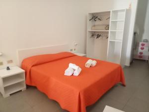 兰佩杜萨Cala Maluk的一间卧室配有橙色床和毛巾