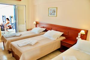 阿齐亚·佩拉加·基西拉维纳德斯酒店的酒店客房设有两张床,阳台上有一位女士。