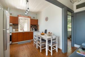 RantátikaChrysa's Hideaway的厨房配有白色的桌子和一些椅子