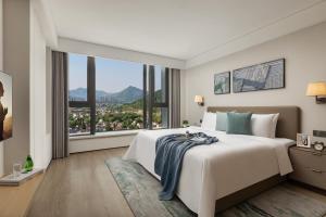 杭州杭州馨乐庭青山湖公寓酒店的一间卧室设有一张大床和一个大窗户