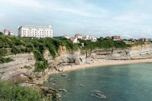 比亚里茨Regina Experimental Biarritz的享有悬崖及海滩和建筑的景色