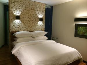 长滩岛长滩岛水之彩潜水度假酒店的一间卧室配有带白色床单和枕头的床。