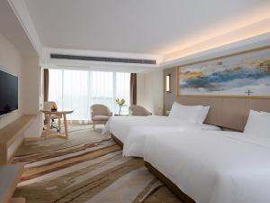 宝安维也纳国际酒店深圳国际会展中心南门店的酒店客房设有两张床和电视。