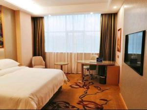 瑞安维也纳国际酒店浙江温州瑞安塘下店的酒店客房设有床、桌子和电视。